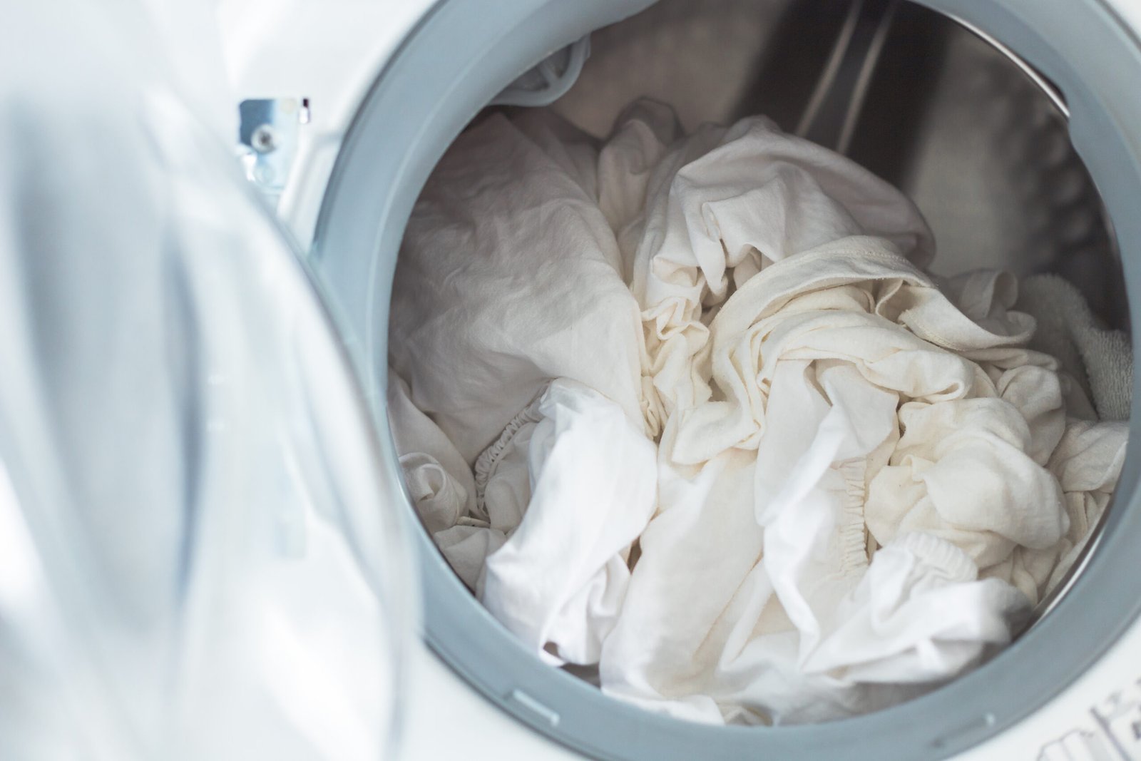 Geöffnete Waschmaschine mit Waschmittel – Pflege gegen muffige Bettwäsche